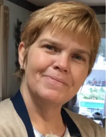 Smiling woman with short blonde hair indoors