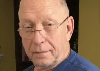 Older man wearing glasses and blue shirt