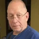 Older man wearing glasses and blue shirt