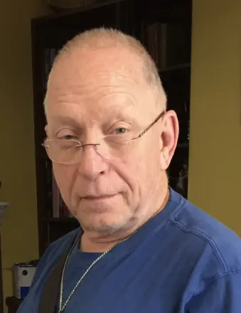 Older man wearing glasses and blue shirt