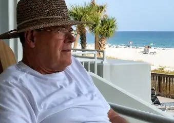 Older man relaxing on beachside balcony