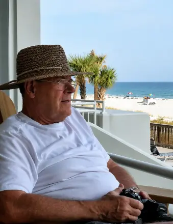 Older man relaxing on beachside balcony