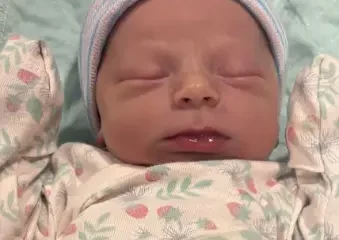 Sleeping newborn baby in striped knit hat