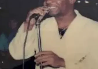 Man singing into microphone on stage