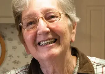 Smiling elderly woman with glasses indoors