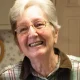 Smiling elderly woman with glasses indoors
