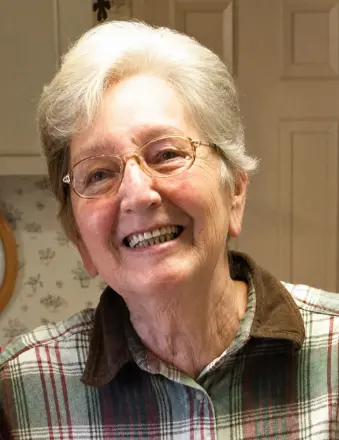 Smiling elderly woman with glasses indoors