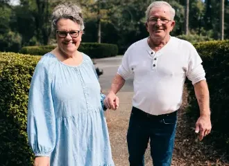 Smiling older couple walking hand in hand outdoors