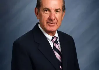 Older man in suit against blue backdrop
