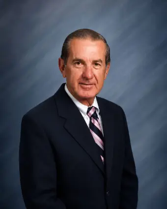 Older man in suit against blue backdrop