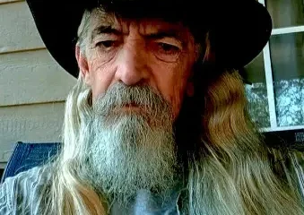 Older man with long gray beard wearing cowboy hat