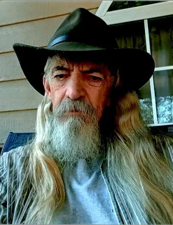 Older man with long gray beard wearing cowboy hat