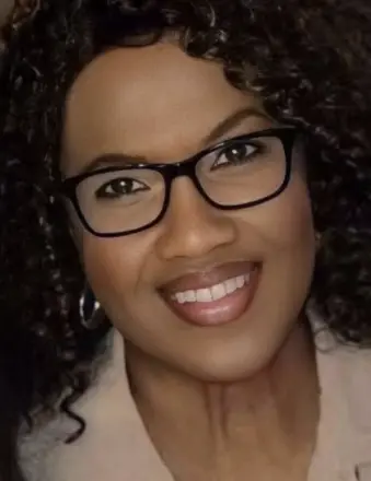 Smiling woman with curly hair and glasses