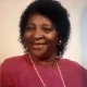 Smiling woman in pink top and pearls