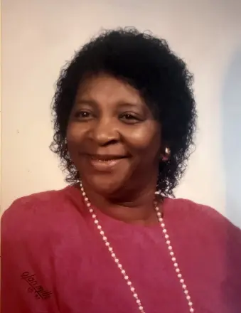 Smiling woman in pink top and pearls