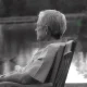 Elderly person sitting by lakeside in chair