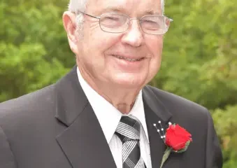 Elderly man in suit with red boutonniere