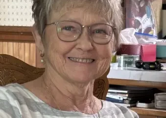 Smiling elderly woman wearing glasses indoors