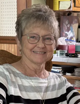 Smiling elderly woman wearing glasses indoors