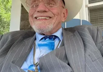 Smiling man in cowboy hat and suit