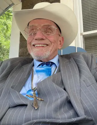 Smiling man in cowboy hat and suit
