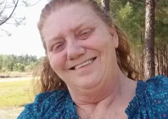 Smiling woman in blue blouse outdoors