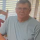 Older man with glasses sitting indoors by window
