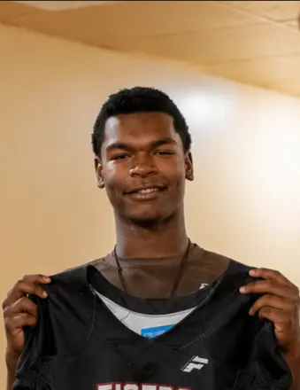 Young man holding up black sports jersey