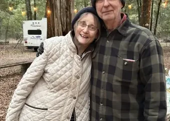 Elderly couple smiling at wooded campsite