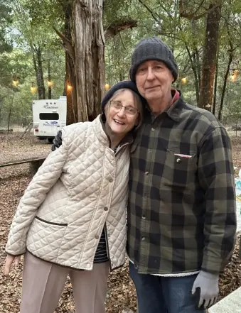 Elderly couple smiling at wooded campsite