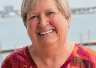 Smiling older woman by waterfront railing