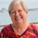 Smiling older woman by waterfront railing