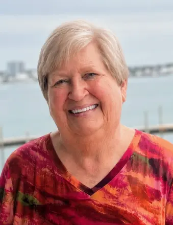 Smiling older woman by waterfront railing