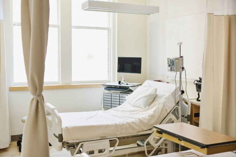 Empty hospital room with bed and medical equipment