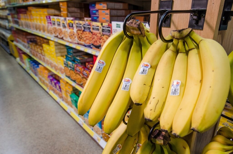 Bananas hanging in grocery store produce section