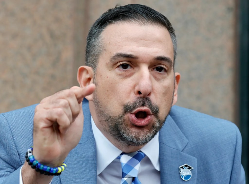 Man in suit speaking and pointing finger