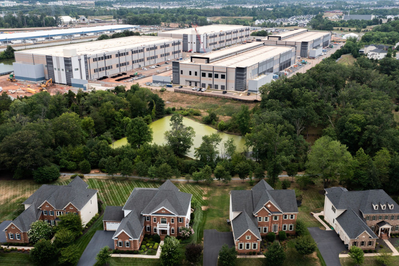 Industrial warehouse complex behind suburban neighborhood homes