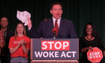 Speaker at podium holding hat at political event