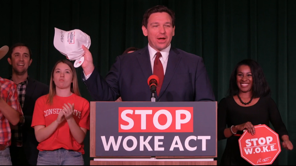 Speaker at podium holding hat at political event
