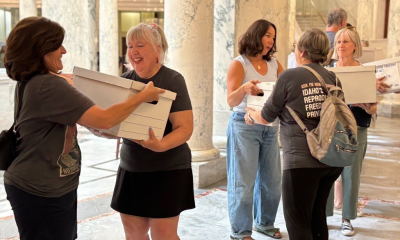 Women carrying document boxes inside marble capitol building