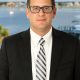Man in suit and glasses by waterfront
