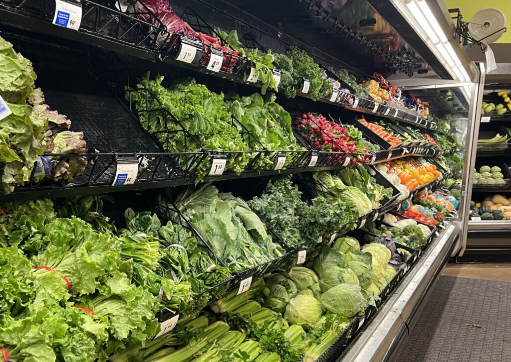 Grocery store produce aisle with fresh vegetables