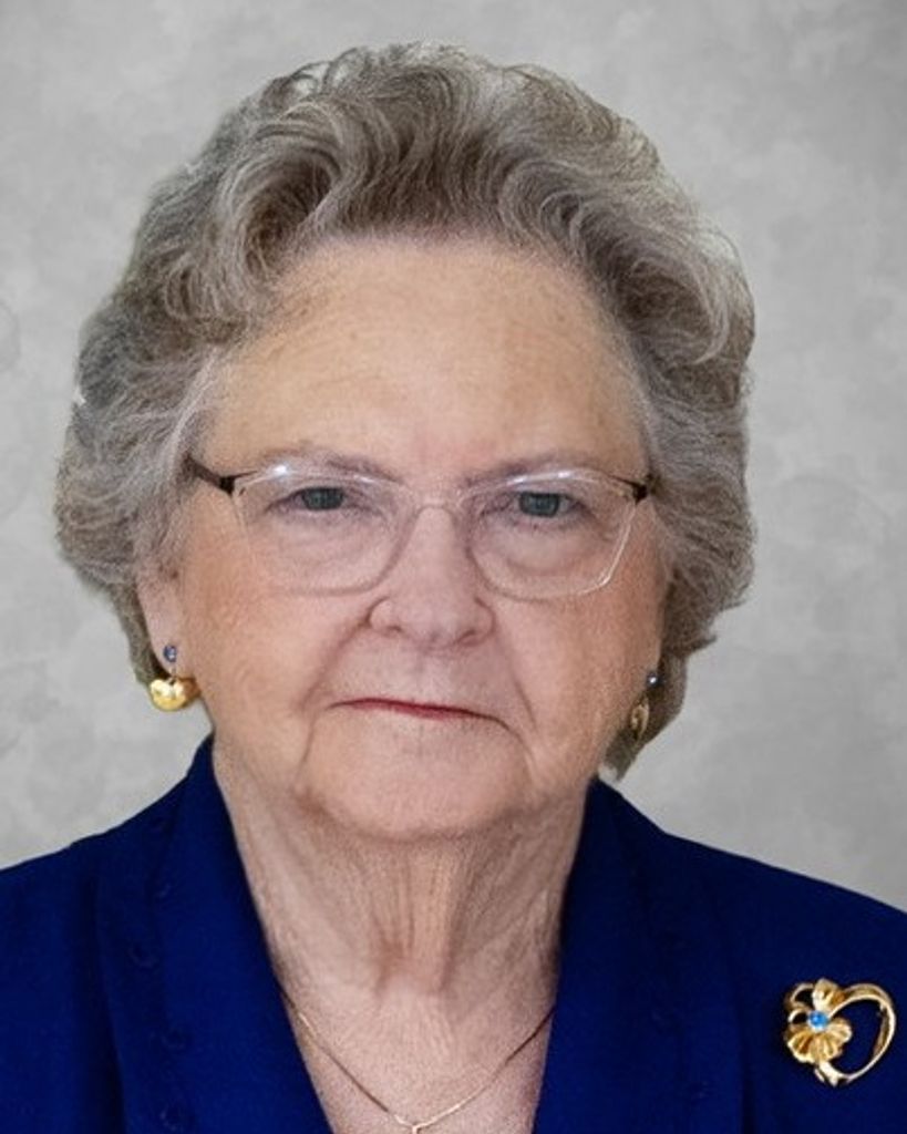 Elderly woman wearing glasses and gold brooch