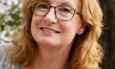 Smiling red-haired woman with glasses outdoors