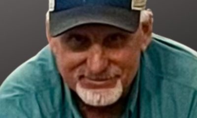 Man wearing forest-print cap and green shirt