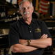 Man in Naval Aviation Museum polo indoors