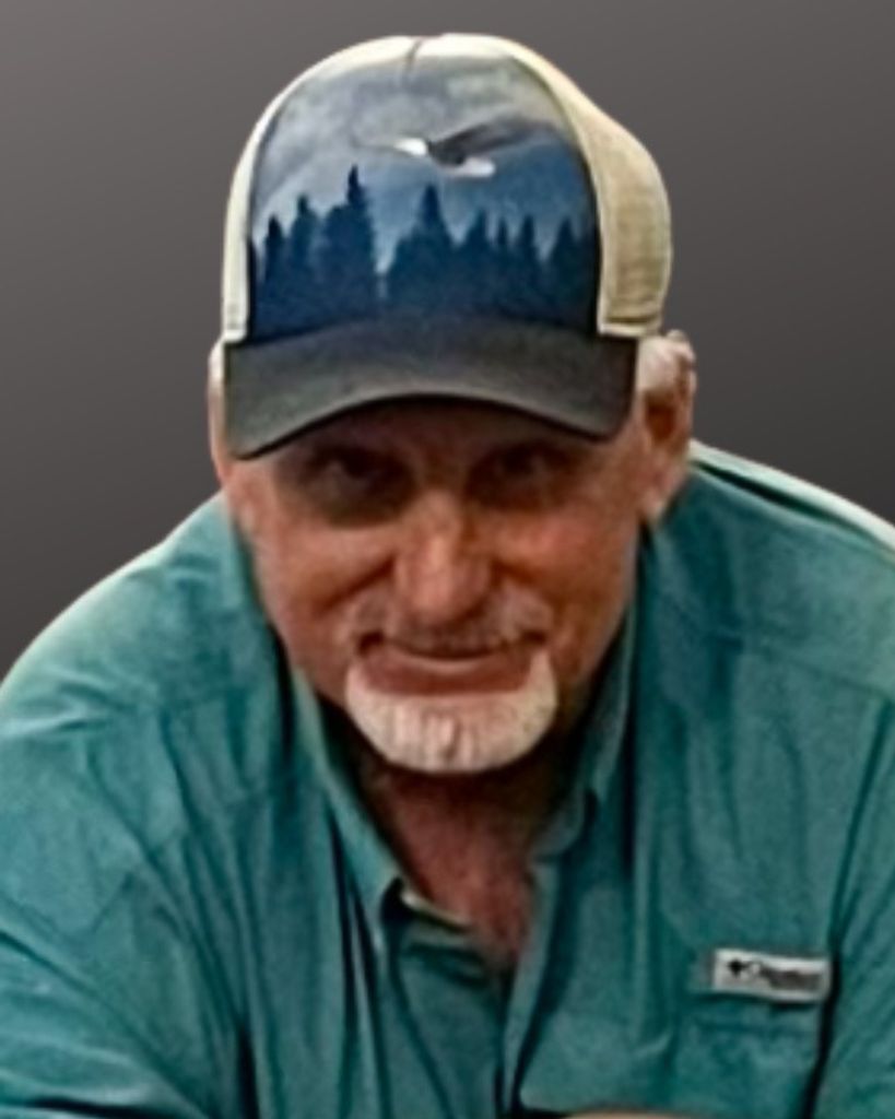 Man wearing forest-print cap and green shirt