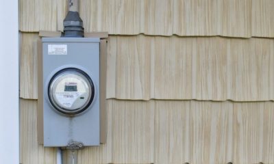 Electric meter mounted on beige house siding