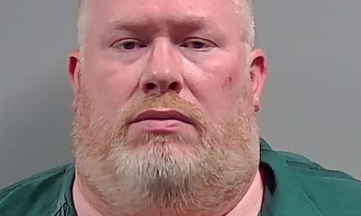 Bearded man in green shirt against gray background