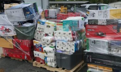 Shrink-wrapped pallets of assorted household goods outdoors